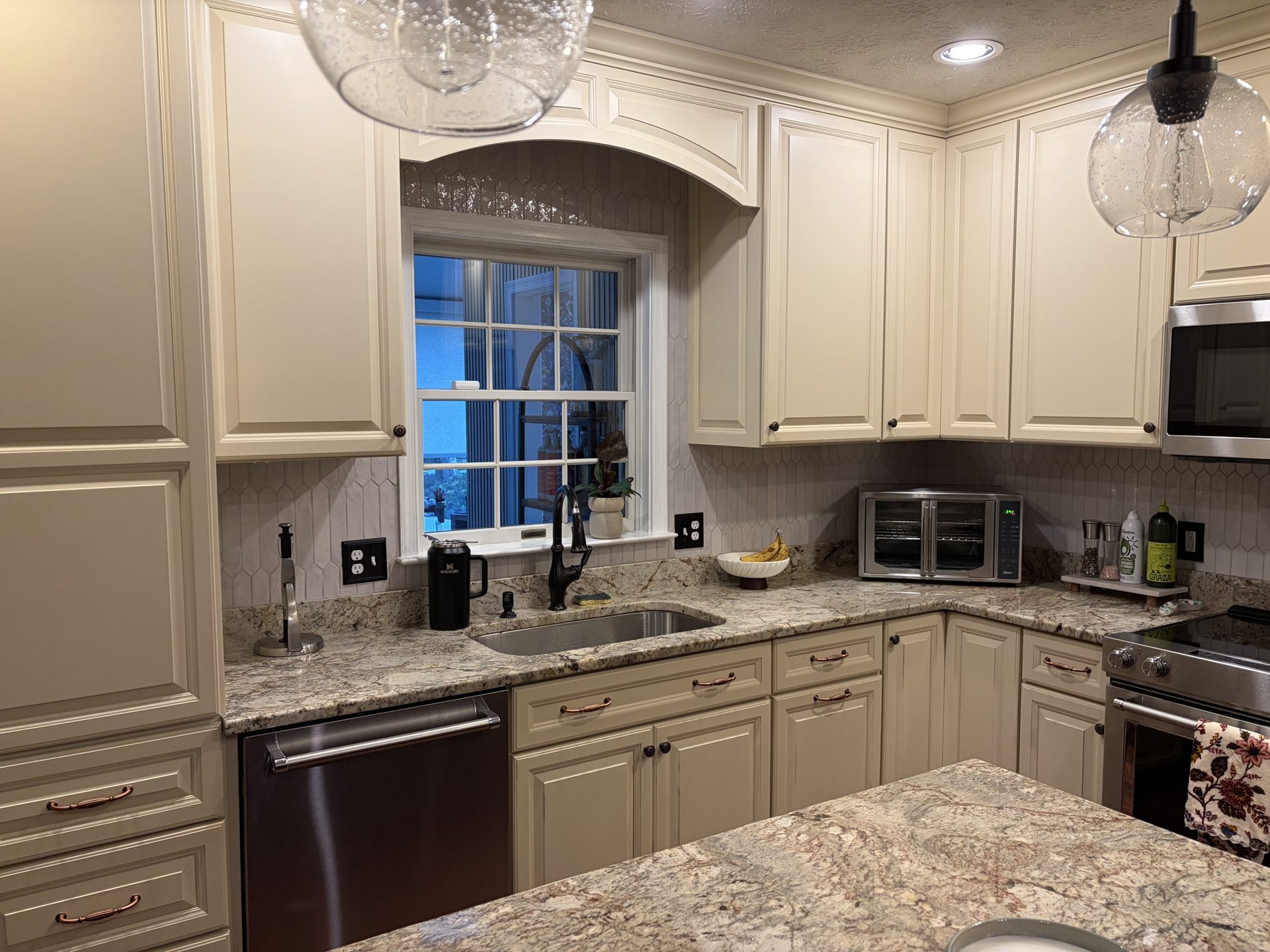 Remodeled white kitchen with brass pendants in Grasonville, MD — Assured Contracting Company